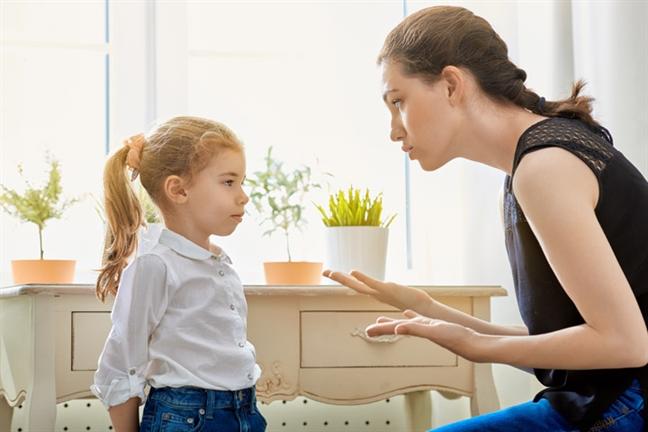 A calm parent talking with a frustrated child.